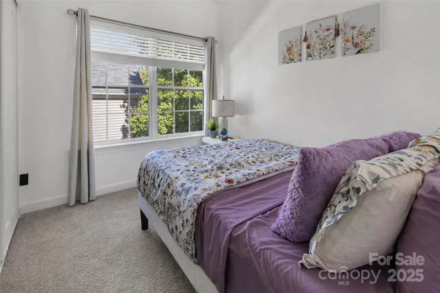 a bed sitting in a bedroom next to a window