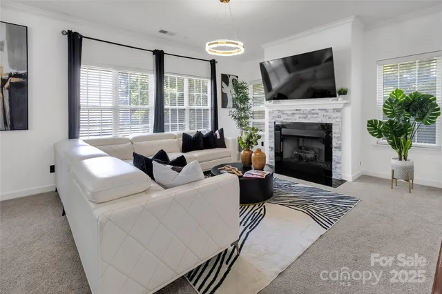 a living room with furniture a fireplace and a flat screen tv