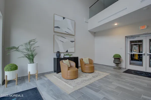 a living room with furniture a potted plant and a kitchen view
