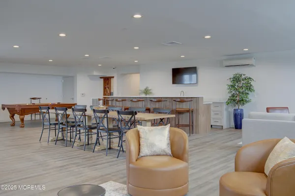 a kitchen with stainless steel appliances a stove a sink dishwasher a refrigerator with a dining table and chairs