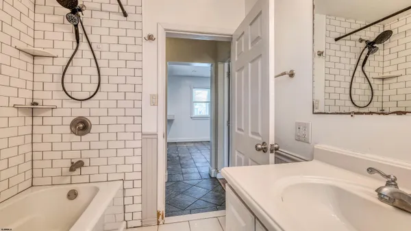 a bathroom with a sink vanity granite shower and a bathtub