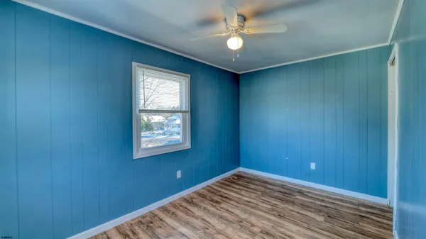 an empty room with a window and ceiling fan