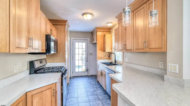 a kitchen with a sink a stove and cabinets