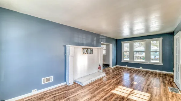 a view of a livingroom with wooden floor and a window