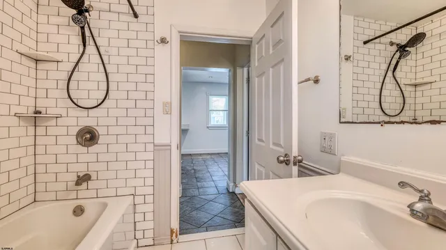 a bathroom with a sink vanity granite shower and a bathtub