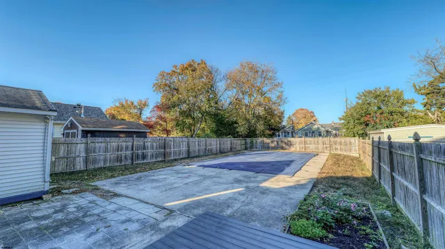 a view of a small house with wooden fence
