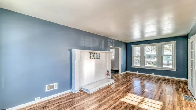 a view of a livingroom with wooden floor and a window