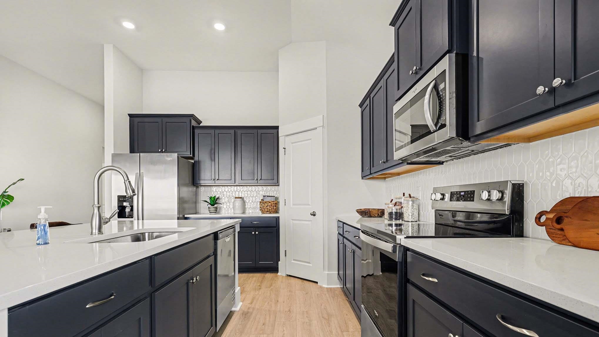 3250 Moss Bridge Lane Myrtle Beach, SC 29579 - Photo 12 of 29 Kitchen featuring stainless steel appliances, light stone countertops, light wood-type flooring, a towering ceiling, and backsplash
