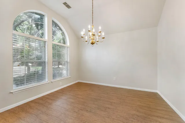 a view of a big room with windows and chandelier