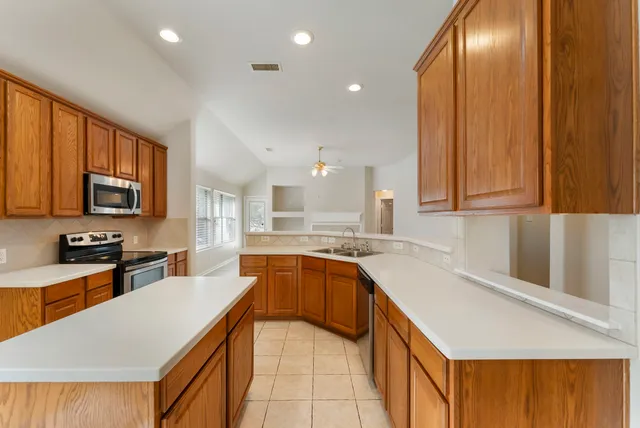 a large kitchen with kitchen island granite countertop a sink and dishwasher stove top oven with granite countertops