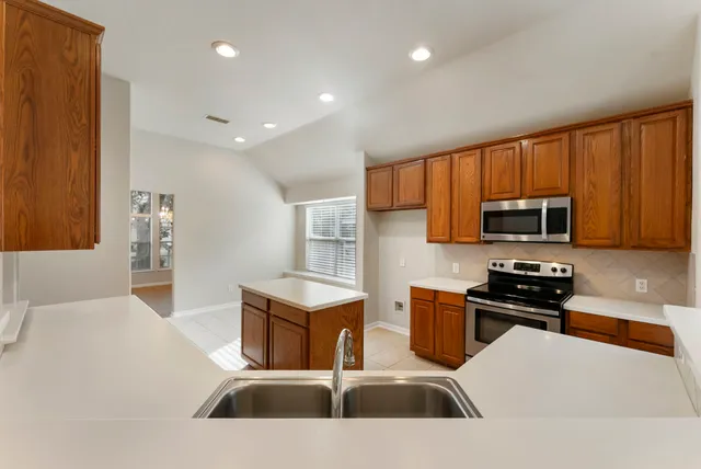 a kitchen with a sink a stove cabinets and a wooden floor