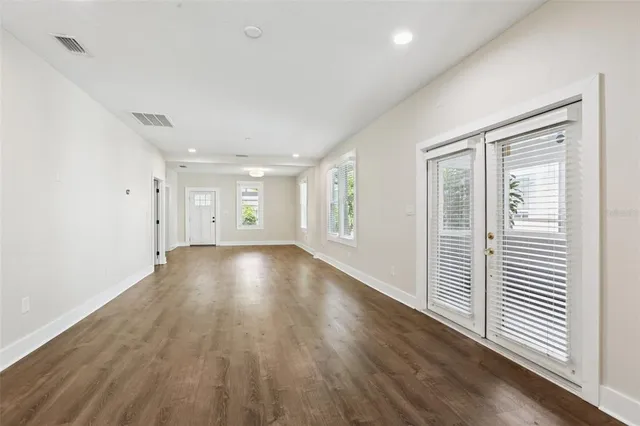 a large kitchen with cabinets wooden floor and stainless steel appliances