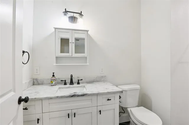 a bathroom with a granite countertop sink toilet a mirror and shower