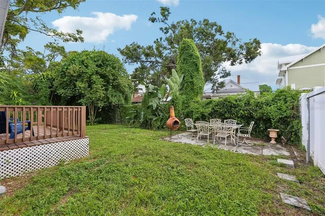 a patio with table and chairs and potted plants