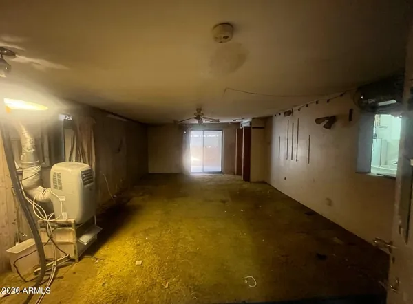 an empty room with windows and fan