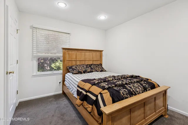 a bed sitting in a bedroom next to a window