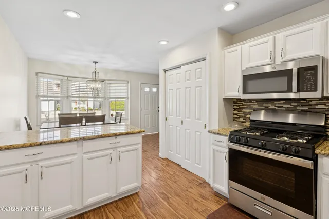 a kitchen with stainless steel appliances granite countertop a stove microwave and sink