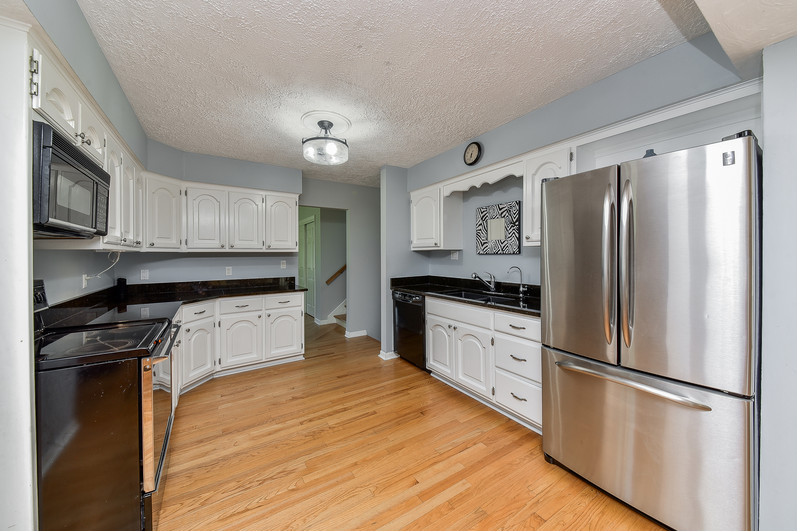 8645 Brookridge Road Downers Grove, IL 60516 - Photo 9 of 23 a kitchen with granite countertop white cabinets and stainless steel appliances