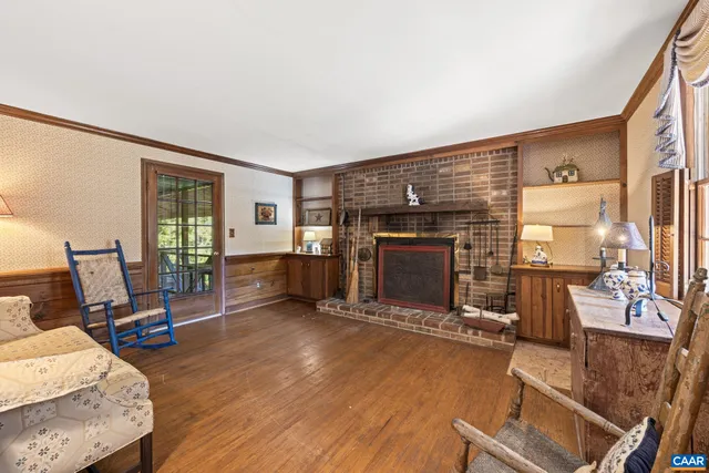 a living room with a couch and a stove with wooden floor