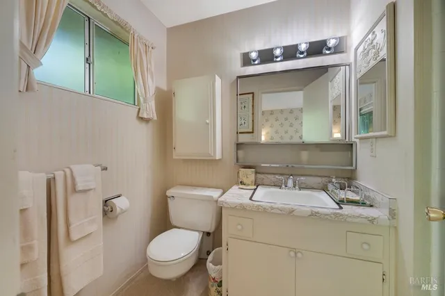 a bathroom with a toilet sink and mirror