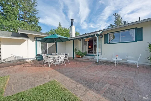 a view of a patio with table and chairs under an umbrella