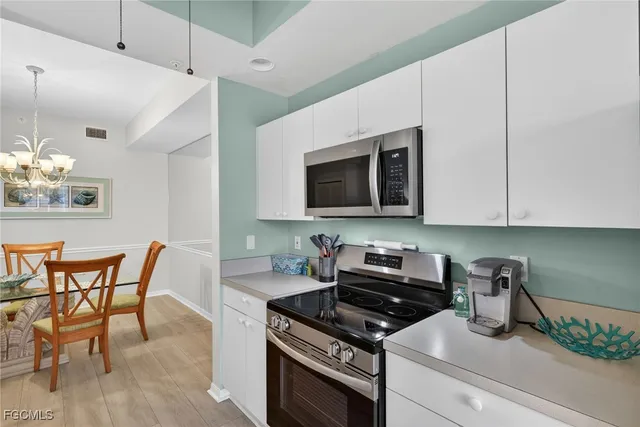 a kitchen with stainless steel appliances kitchen island granite countertop a stove a sink and a microwave