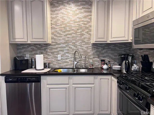 a kitchen with stainless steel appliances granite countertop a sink stove and cabinets