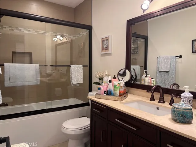 a bathroom with a double vanity sink toilet and a mirror