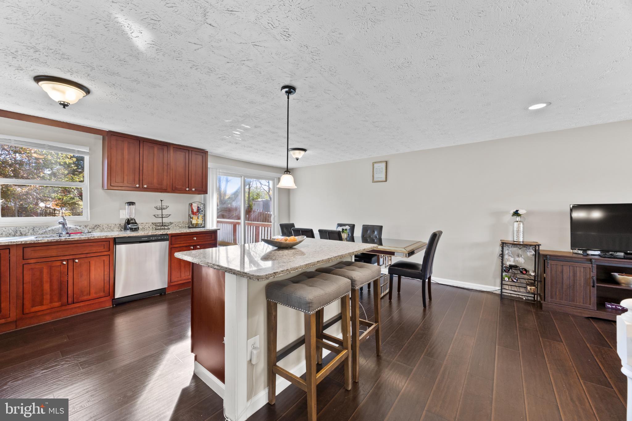 8600 Temple Hill Road Clinton, MD 20735 - Photo 5 of 31 a kitchen with granite countertop a table chairs stove a sink dishwasher and cabinets with wooden floor