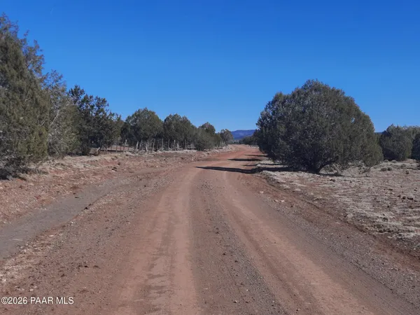 a view of dirt road with a building in the background