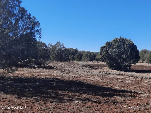 a view of a dirt road with a building in the background
