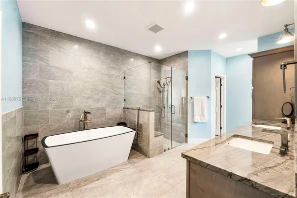 a bathroom with a granite countertop sink a toilet a mirror a bathtub and shower