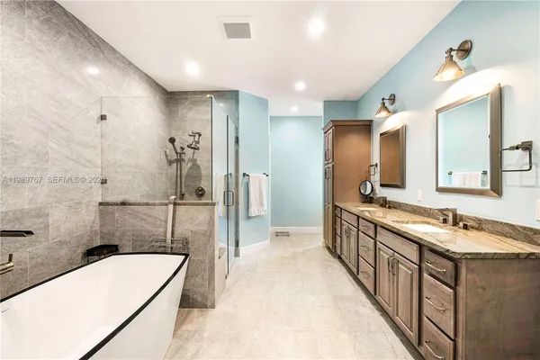 a bathroom with a tub sink shower and mirror