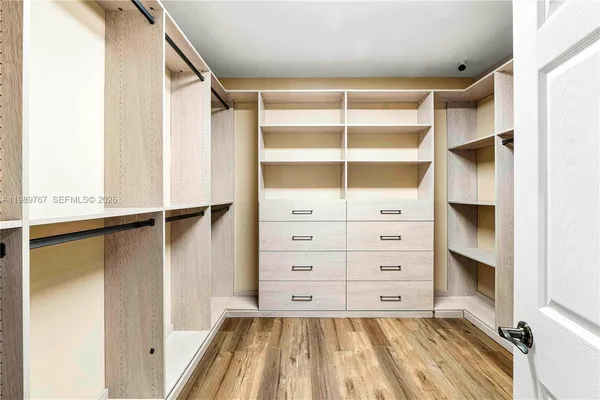 a view of walk in closet with empty racks