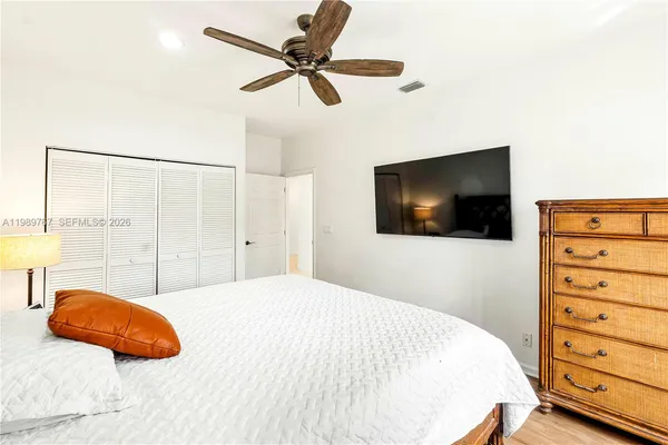 a bedroom with a large bed and a flat tv screen on dresser