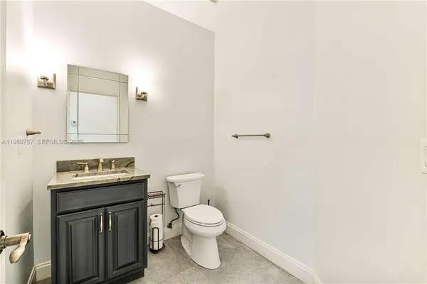 a bathroom with a toilet a sink and mirror