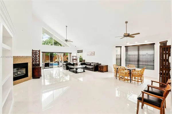 a view of a livingroom with furniture a fireplace and chandelier