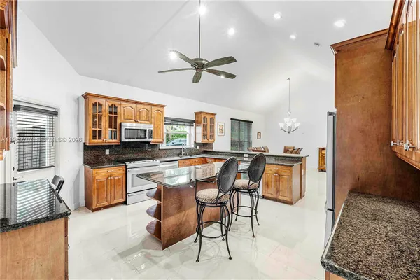 a kitchen with a refrigerator a stove top oven a sink dishwasher and white cabinets with wooden floor
