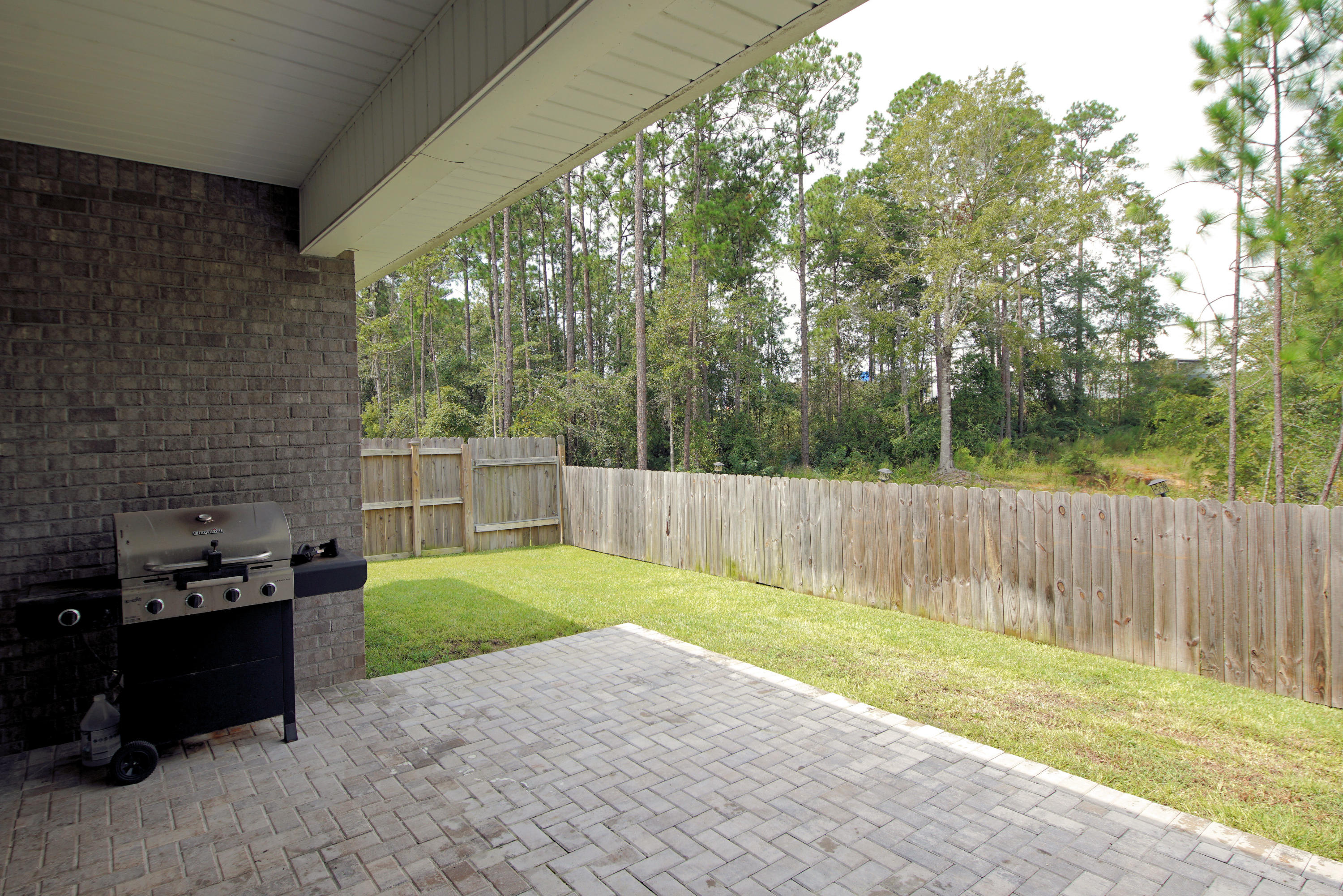 4520 Hermosa Road Crestview, FL 32536 - Photo 43 of 43 a view of a backyard with a large tree and wooden fence