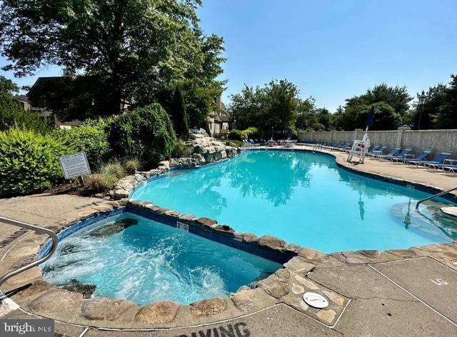 29 Gate House Lane Edison, NJ 08820 - Photo 31 of 35 a view of a swimming pool with lawn chairs under an umbrella