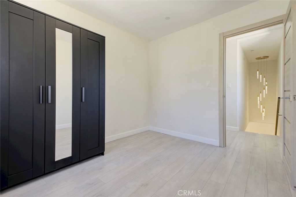 7044-1 Greeley Street Tujunga, CA 91042 - Photo 18 of 27 an empty room with wooden floor and a hallway