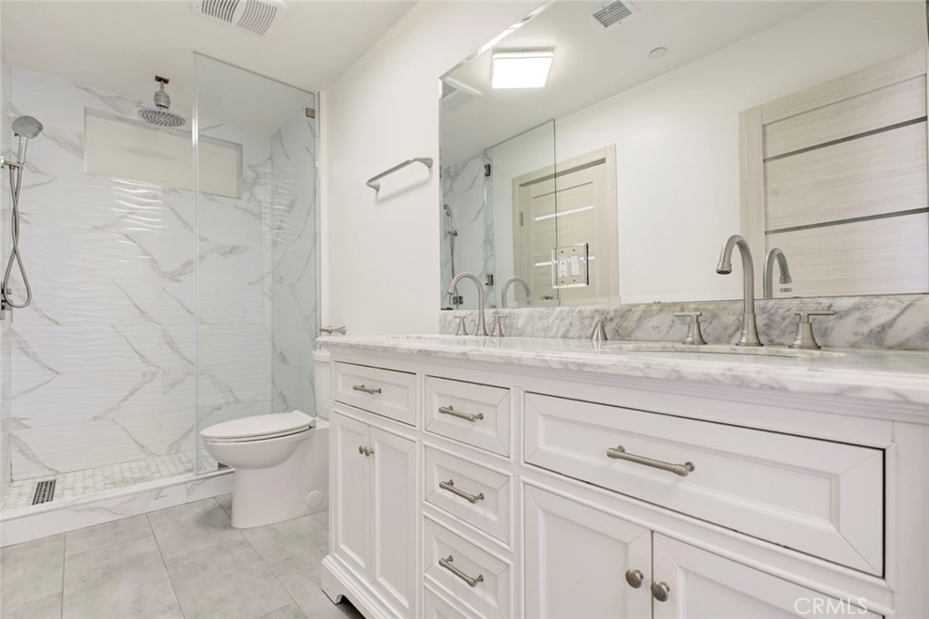 7044-1 Greeley Street Tujunga, CA 91042 - Photo 20 of 27 a bathroom with a granite countertop toilet sink and mirror