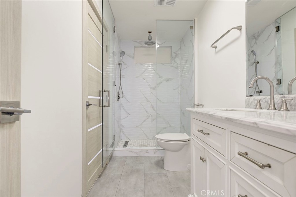 7044-1 Greeley Street Tujunga, CA 91042 - Photo 21 of 27 a bathroom with a granite countertop sink a toilet and shower