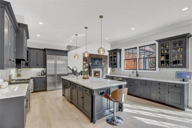 a kitchen with stainless steel appliances granite countertop a sink a stove and a wooden floors