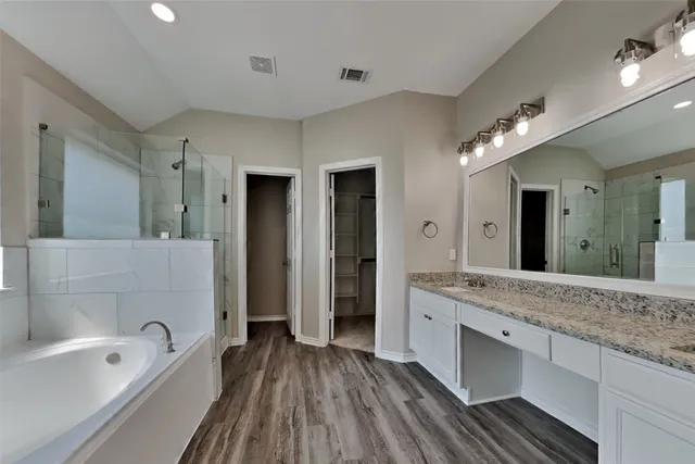 a spacious bathroom with a granite countertop sink mirror and bathtub