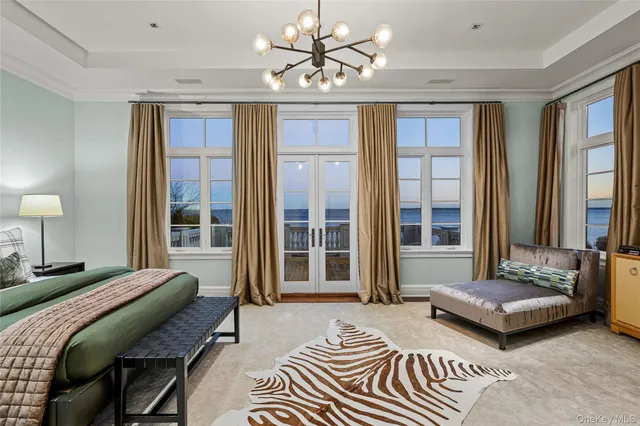 a bedroom with a bed a couch and a large window