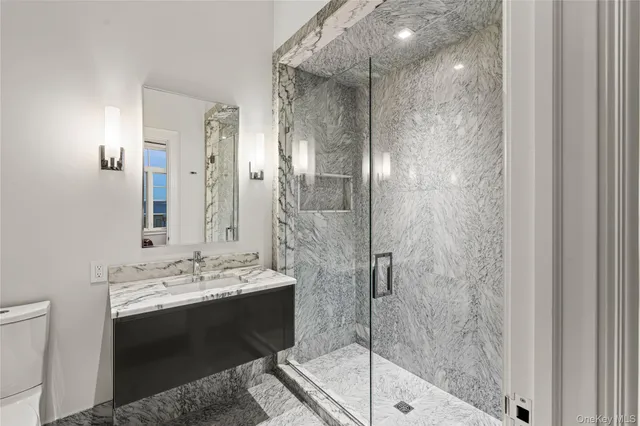 a bathroom with a sink a toilet and shower