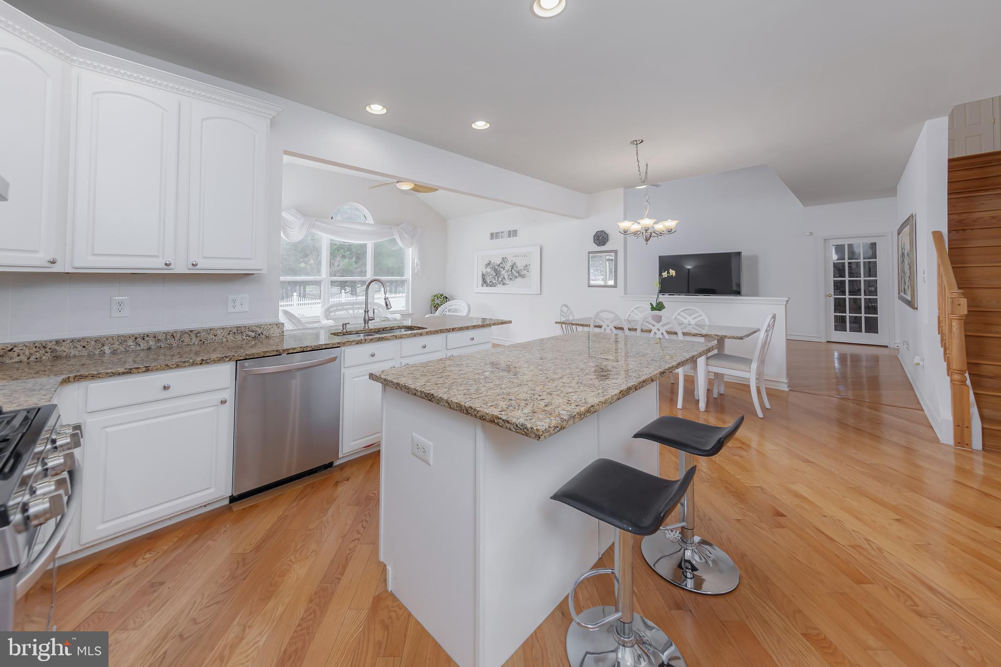 316 Pickwick Drive Williamstown, NJ 08094 - Photo 8 of 44 a kitchen with granite countertop a stove top oven a sink dishwasher and white cabinets with wooden floor