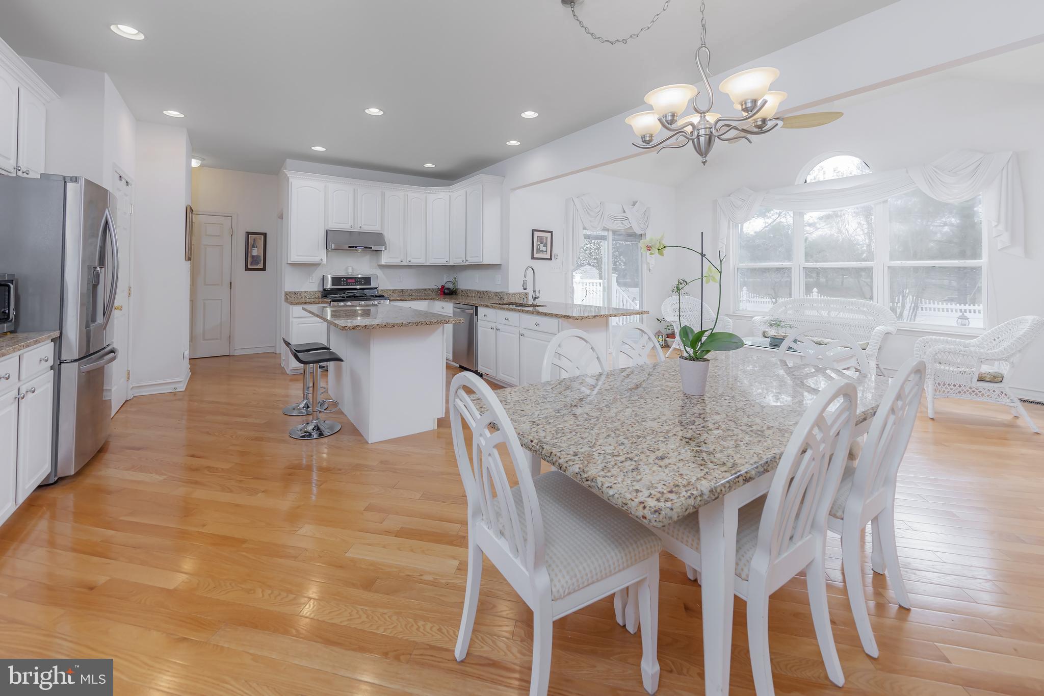 316 Pickwick Drive Williamstown, NJ 08094 - Photo 9 of 44 a kitchen with stainless steel appliances kitchen island granite countertop a table chairs and a refrigerator