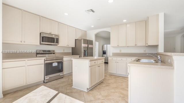 12838 Southwest 47th Street Miramar, FL 33027 - Photo 6 of 40 a kitchen with a sink stove and refrigerator